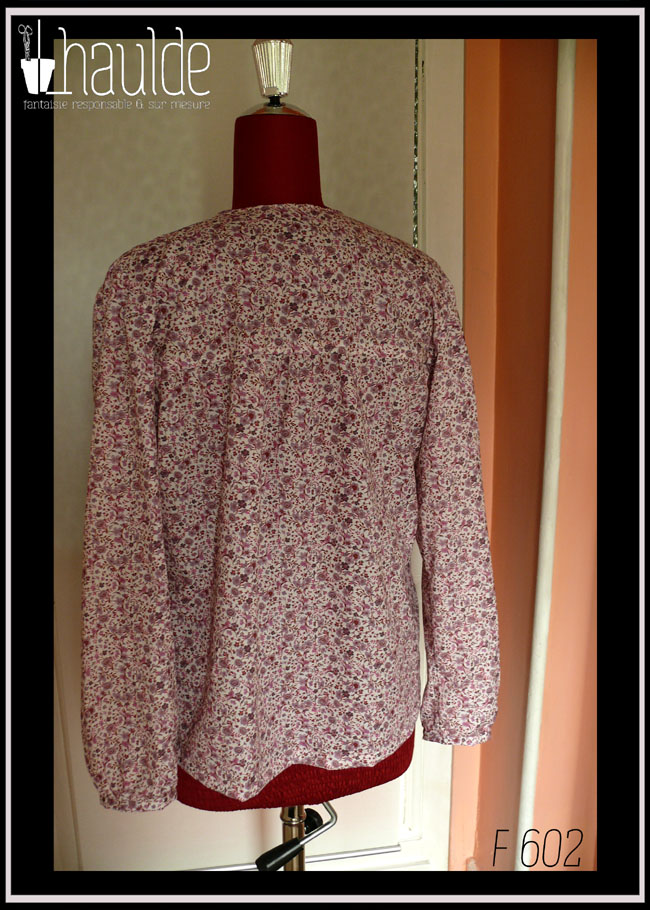 Blouse col V échancré, manches longues en popeline blanche imprimé petites fleurs mauves et roses Vue de dos sur un mannequin de couture