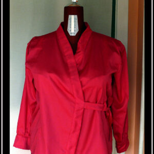 Chemisier croisé sur le devant, noué côté gauche, à manches longues en satin rose vif. Col châle plat Vu de face sur un mannequin de couture