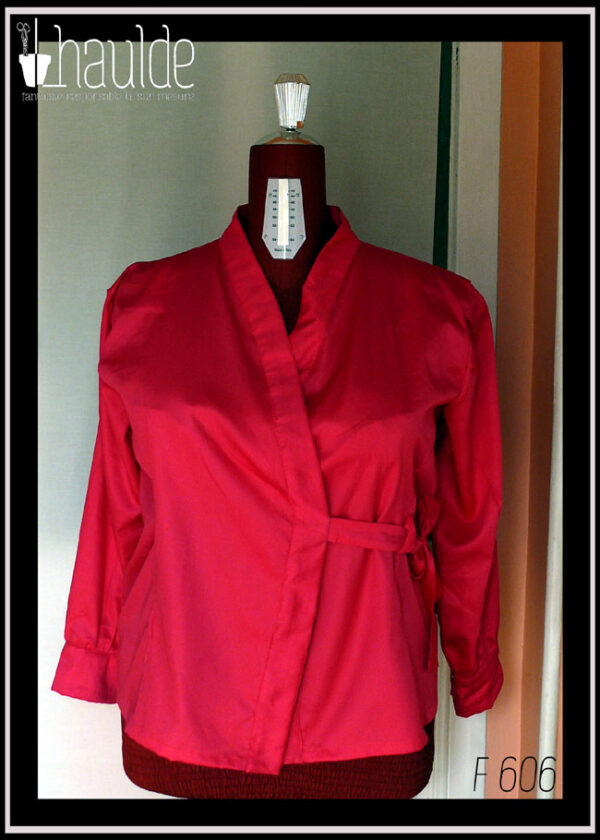Chemisier croisé sur le devant, noué côté gauche, à manches longues en satin rose vif. Col châle plat Vu de face sur un mannequin de couture