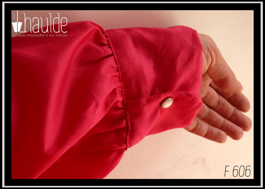 détail de la manchette fermée par un bouton pression couleur perle