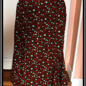 Jupe longue à quilles en coton noir imprimé petites fleurs rouges et bleu pâle vif Vue de face sur un mannequin de couture