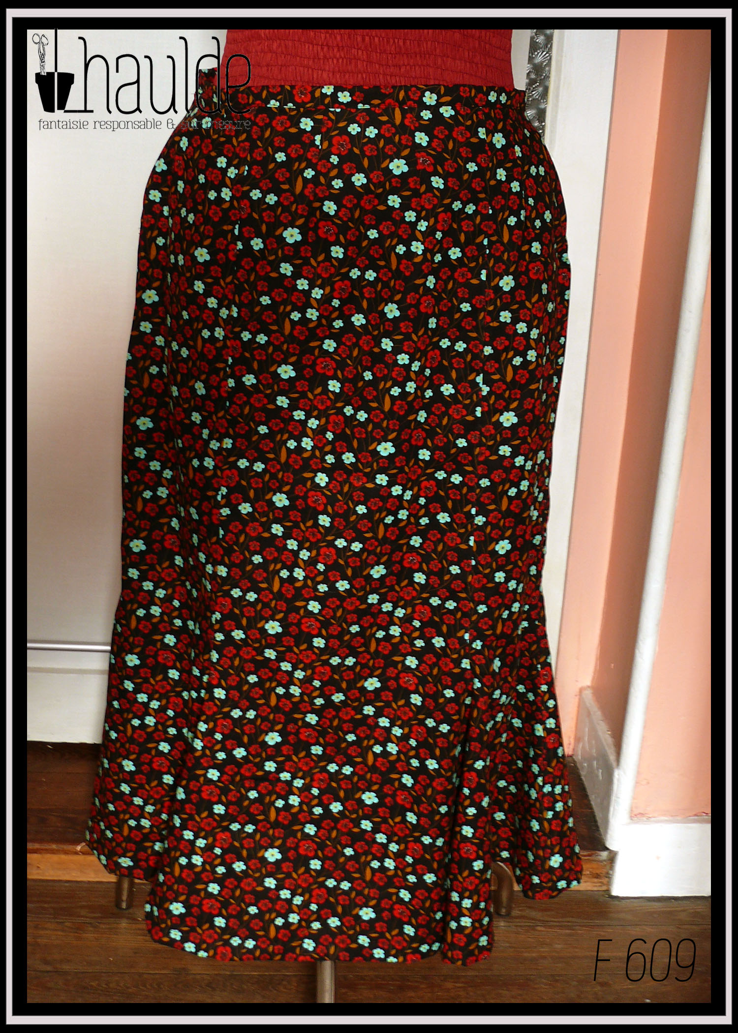 Jupe longue à quilles en coton noir imprimé petites fleurs rouges et bleu pâle vif Vue de face sur un mannequin de couture