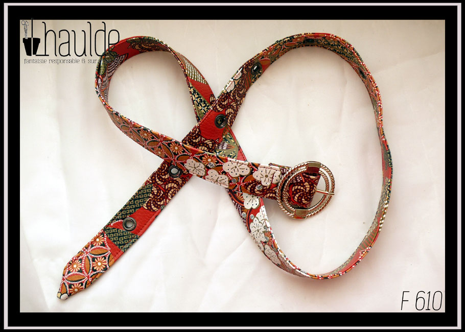 Ceinture en simili cuir rouge imprimé motifs floraux d'inspiration japonaise Boucle ronde à deux cercles concentriques torsadés, en acier légèrement doré Sept oeillets en acier couleur bronze