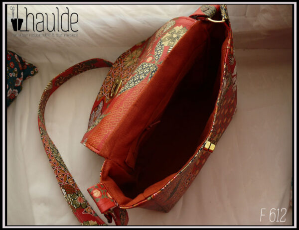 vue de dessus du sac ouvert, on devine la poche intérieure zippée Doublure en sergé de coton couleur brique Le reste du sac est en simili cuir rouge imprimé motifs floraux d'inspiration japonaise