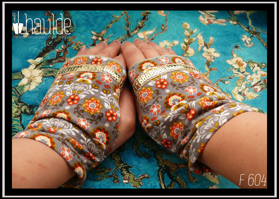 Mitaines en velours milleraies gris imprimé motifs végétaux stylisés dans les tons oranges et blanc Un galon de sequins carrés dorés sur deux rangs garnit les phalanges Vues portées