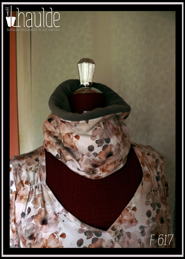 Tour de cou en jersey blanc imprimé fleurs aquarellées dans les tons oranges et gris. Vu relevé, on devine la doublure en velours gris sur le bord