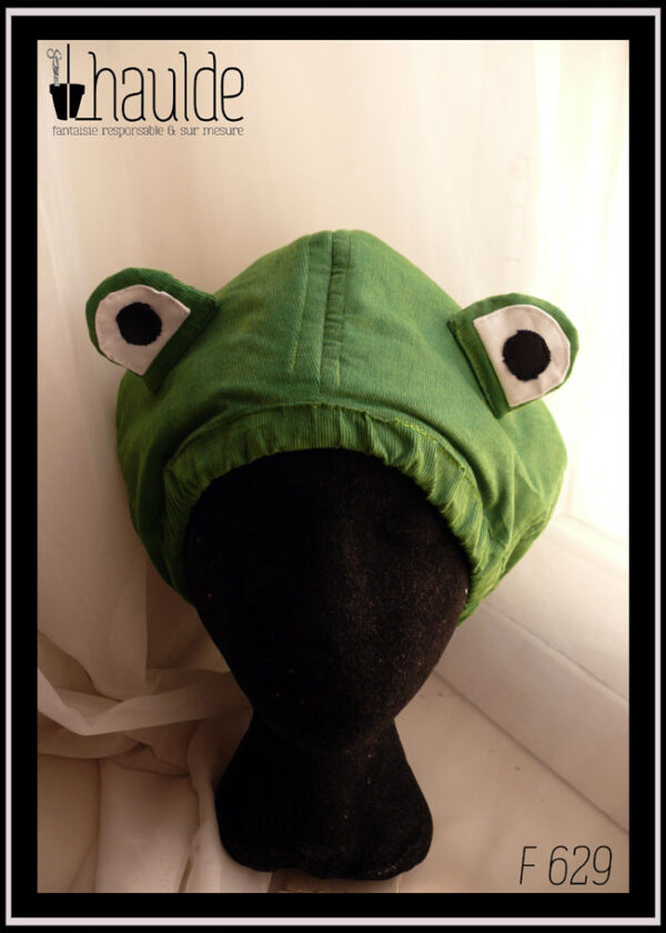 Bonnet en velours milleraies vert clair avec deux yeux sur le dessus pour figurer une tête de grenouille Vu de face sur une tête de mannequin