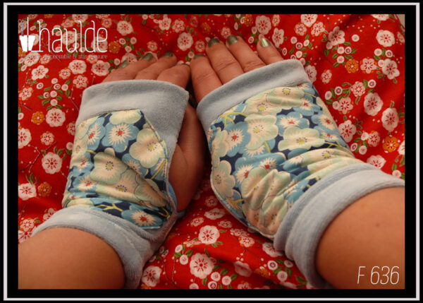 Mitaines en velours bleu pastel avec au milieu une large bande de tissu imprimé fleurs de cerisiers bleues stylisées Vue de dessus, portées