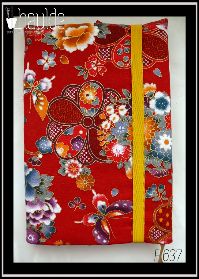 Protège carnet en tissu rouge imprimé fleurs et papillons d'esthétique japonaise. Vu fermé côté dos, avec un élastique jaune