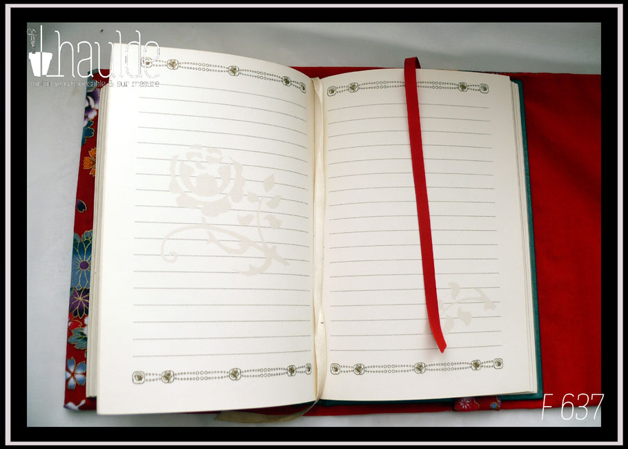 Protège carnet en tissu rouge imprimé fleurs et papillons d'esthétique japonaise. Intérieur rouge uni, signet rouge, vu sur un carnet ouvert