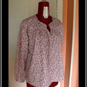 Blouse col V échancré, manches longues en popeline blanche imprimé petites fleurs mauves et roses Vue de face sur un mannequin de couture
