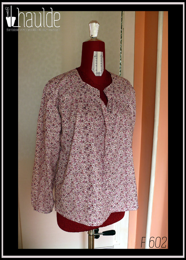 Blouse col V échancré, manches longues en popeline blanche imprimé petites fleurs mauves et roses Vue de face sur un mannequin de couture