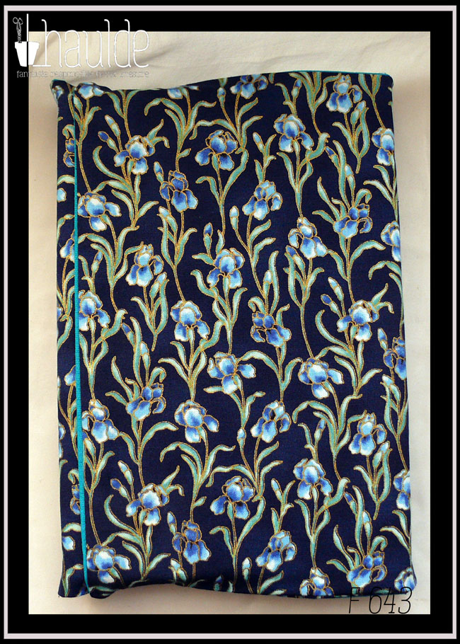 Protège livre en tissu bleu marine imprimé iris bleus; Les iris sont sur tige avec leurs feuilles et détouré d'une très fine ligne dorée Vu fermé