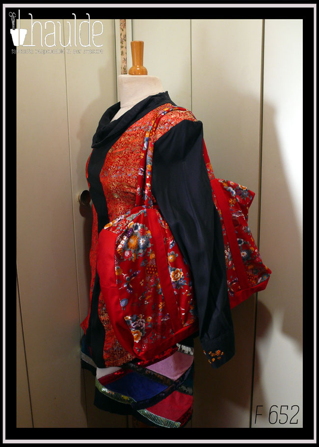 Grand sac en toile à anse. Tissu rouge imprimé pivoines et autres fleurs multicolores soulignées de dorées, d'inspiration Est asiatique (Chine ou Japon), petits côtés, dessous et bandes de renfort en sergé rouge Vu porté par un mannequin de couture vêtu d'un haut noir et rouge (référence F 159) et d'une jupe noire décorée de losanges et de galons de sequins (référence F 169)