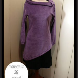 Haut manches longues, col bateau rabattu en velours mauve, vu de face sur un mannequin de couture, taille 38. Le bas est asymétrique, il s'arrête au niveau des hanches à droite et descend 20 cm plus bas côté gauche Le mannequin porte également une jupe courte noire