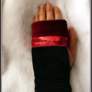 Mitaine en velours, côté phalanges du velours rouge bordeaux, le reste en velours noir séparé du rouge par un galon de sequins carrés rouges sur 5 rangs Vue portée, de dessus