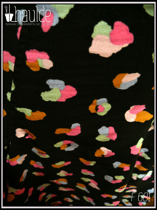 Vue de détail du velours milleraies noir imprimé de taches regroupées par trois ou quatre, mauve, vert pâle, ocre, rose et bleu, qui pourraient faire penser à un pelage animal (le motif s'appelle animal skin) Vue de face sur un mannequin de couture