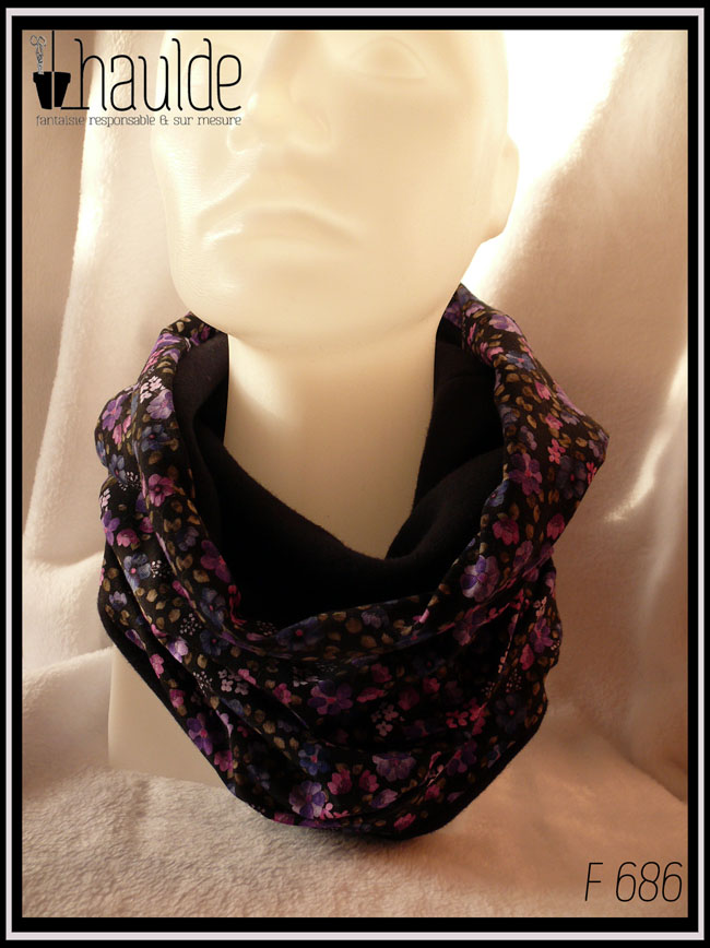 Tour de cou en jersey noir imprimé petites fleurs réalistes dans les tons violets doublé de polaire de coton noire Vu porté sur une tête de mannequin de trois quarts face