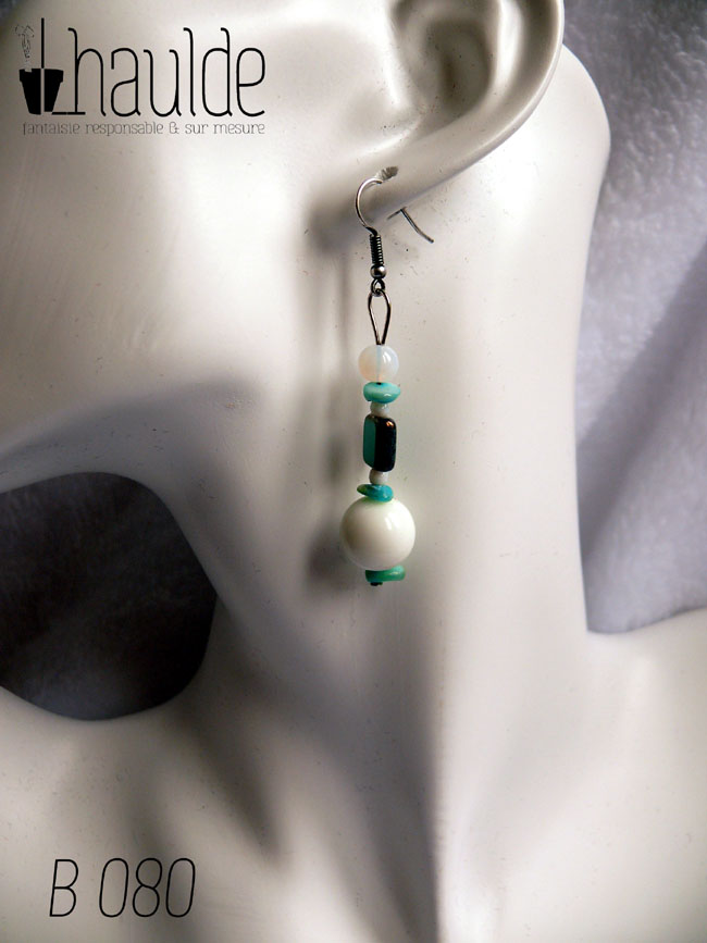 boucles d'oreilles montées sur crochet, perles en verre alignées à la verticale, perle ronde blanche opalescente, chips de couleur turquoise, perle carrée turquoise à tranche dorée, petite perle blanche, chips couleur turquoise, grosse perle blanche, chips couleur turquoise Vue portée par une tête de mannequin