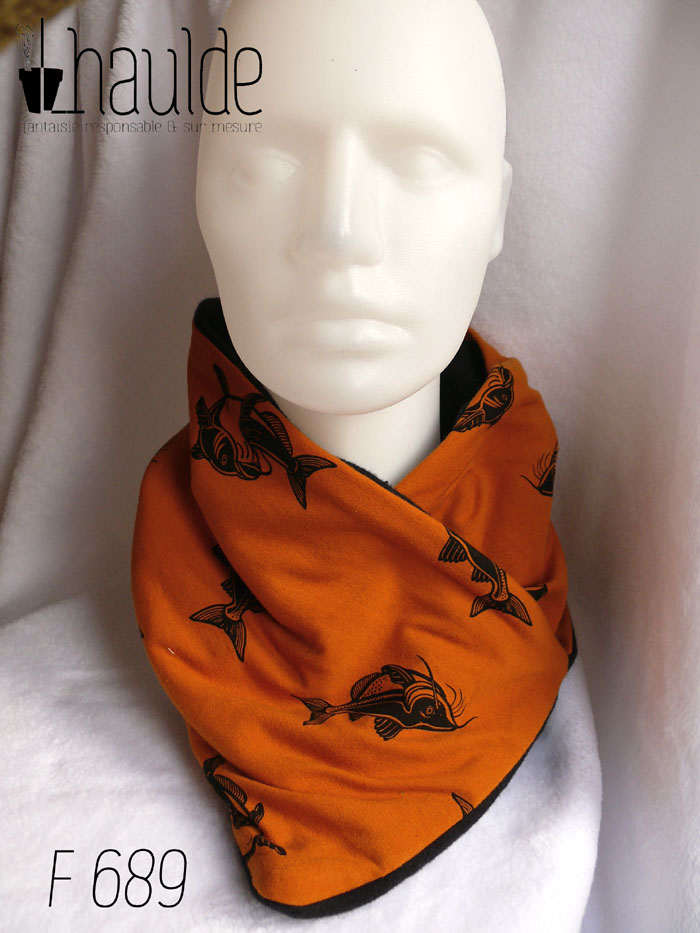 Cache col croisé, le côté droit sur le côté gauche, en jersey ocre foncé imprimé carpes noires (qui sont malheureusement mal orientées, tête en bas) Doublé de polaire de coton noir Vu de face sur une tête de mannequin