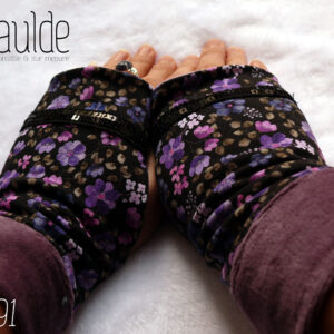 Paire de mitaines en jersey noir imprimé petites fleurs violettes. Un galon de deux rangs de sequins noirs décore au niveau des phalanges. Manchettes en velours mauve Vue de la paire portée