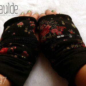 Paire de mitaines en jersey noir imprimé petits bouquets de roses rouges et autres fleurs. Au niveau du pouce un galon de deux rangs de sequins noirs traverse horizontalement la mitaine. Manchettes en jersey noir uni Vue de la paire portée