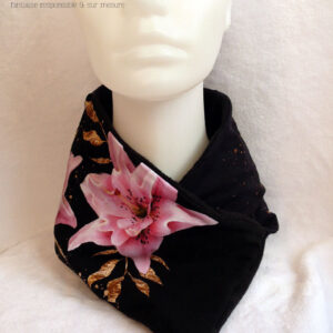 Tour de cou croisé en jersey noir imprimé fleurs de lys roses réalistes façon 3D avec un feuillage doré Doublure en polaire noire Vue de face sur une tête de mannequin