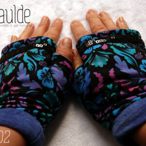 Paire de mitaines avec pouce long en jersey noir imprimé motifs végétaux stylisés et symétriques dans les tons bleus électriques, turquoise, fuchsia et mauve Le haut de la mitaine est traversé par un galon de deux rangs de sequins carrés noirs. La manchette est en velours bleu roi Vue de la paire, portée