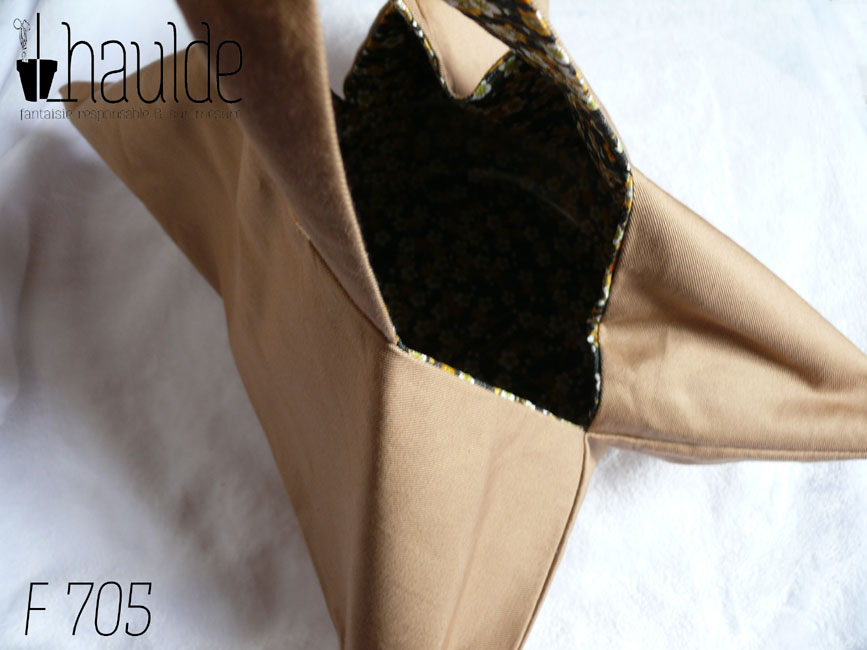 sac à tarte en sergé beige, doublé de toile noire imprimé petites fleurs dans les tons ocres et blanc. Deux anses Vu suspendu par les anses