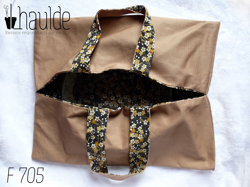 sac à tarte en sergé beige, doublé de toile noire imprimé petites fleurs dans les tons ocres et blanc. Deux anses Vu de dessus, entrouvert avec un plat à manqué en pyrex à l'intérieur (on le distingue à peine)