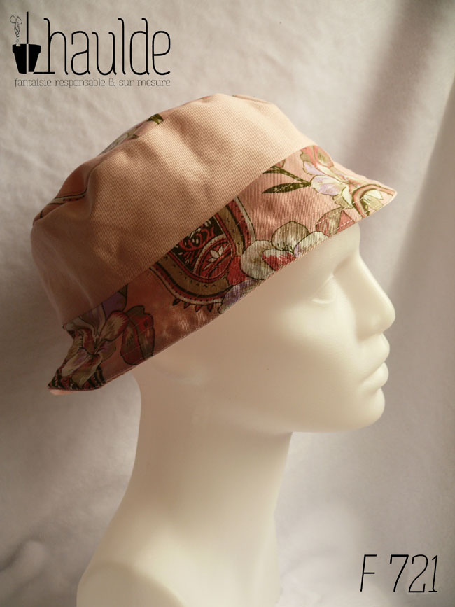 Bob court en toile rose et toile rose imprimée de motifs fleuris également roses et soulignés de vert foncé. Ici la bande centrale est en uni rose pâle, le bord en imprimé Vu de profil sur une tête de mannequin