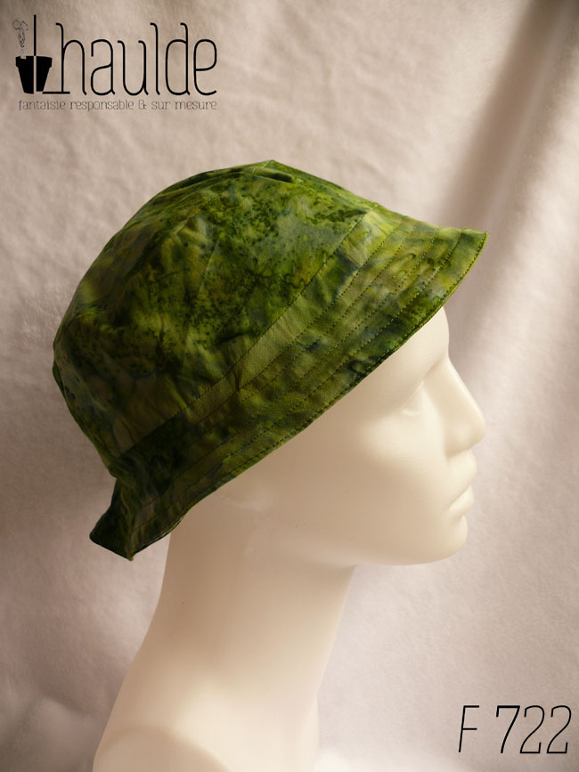 Bob court dans les tons verts, imprimé de motifs abstraits comme de l'aquarelle très humide. Vu de profil sur une tête de mannequin