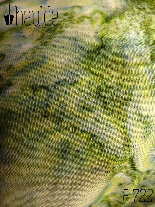 Vue de détail du tissu qui oscille entra lavis et textures comme de la mousse, le tout traité comme de l'aquarelle dans les tons verts clairs.