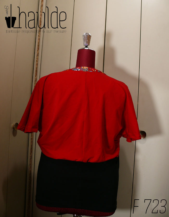 Haut coeur croisé à manches courtes en jersey rouge qui blouse jusqu'à la taille et jersey noir moulant de la taille aux hanches Le col est garni de tissu rouge imprimé fleurs et papillons d'inspiration Est asiatique, soulignés de doré. Vu de dos sur un mannequin de couture réglé en taille 52