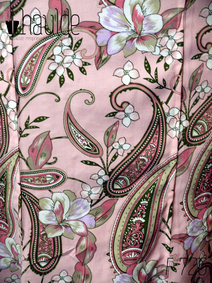 Détail du tissu sergé de viscose rose pâle imprimé paisley et fleurs dans les tons roses et gris, soulignés de vert foncé, rehaussés de blanc.