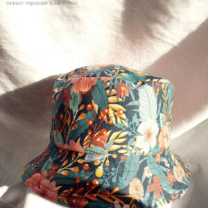 Bob en gabardine imprimée de motifs feuillage vert pastel et fleurs roses sur fond bleu marine. Vu sur une tête de mannequin, de dessus