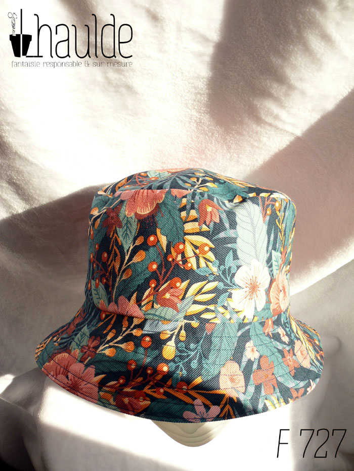 Bob en gabardine imprimée de motifs feuillage vert pastel et fleurs roses sur fond bleu marine. Vu sur une tête de mannequin, de dessus