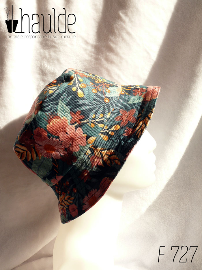 Bob en gabardine imprimée de motifs feuillage vert pastel et fleurs roses sur fond bleu marine. Vu de profil sur une tête de mannequin