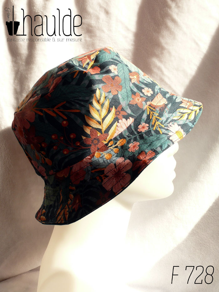 Bob en gabardine imprimée de motifs feuillage vert pastel et fleurs roses sur fond bleu marine. Vu de profil sur une tête de mannequin