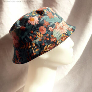 Bob court en gabardine imprimée de motifs feuillage vert pastel et fleurs roses sur fond bleu marine. Vu de profil sur une tête de mannequin