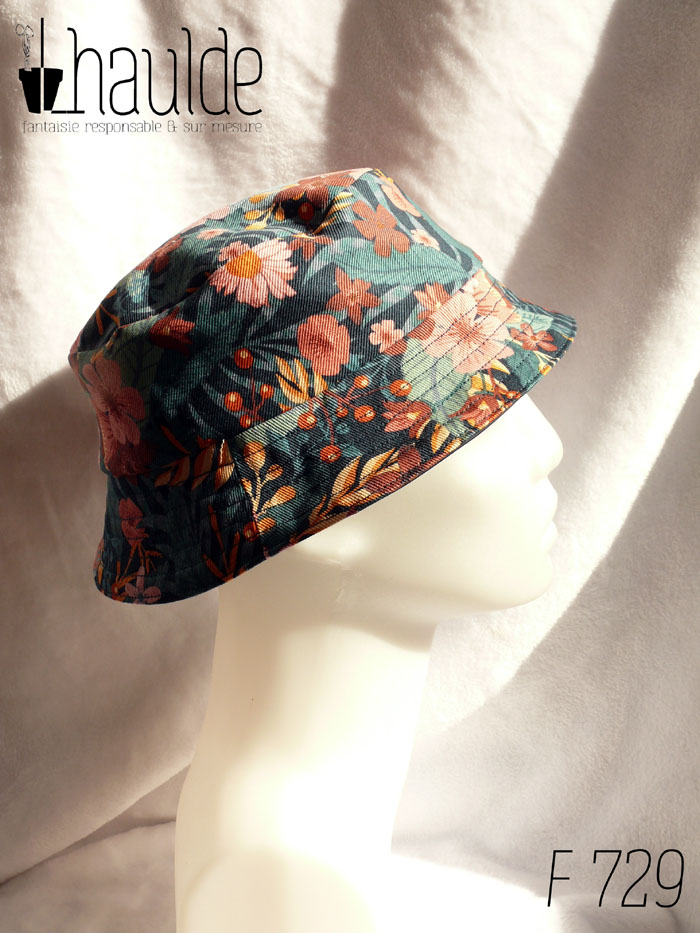 Bob court en gabardine imprimée de motifs feuillage vert pastel et fleurs roses sur fond bleu marine. Vu de profil sur une tête de mannequin