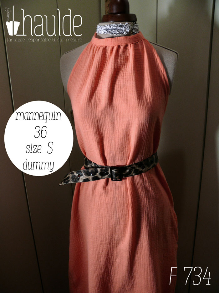 La robe portée avec une ceinture imprimée panthère Robe mi longue dos nu nouée autour du cou, sans décolleté, en double gaze corail clair un peu orangé. Vue de face sur un mannequin de couture réglé en taille 36/S