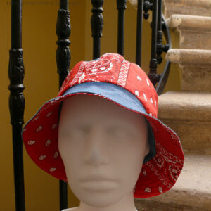 Bob classique en jean et tissu rouge imprimé "bandana" Bord jean, bande centrale rouge, sommet jean, vu de face sur une tête de mannequin Sur l'envers les bandes sont inversées