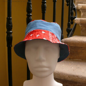 Bob court en jean et tissu rouge imprimé "bandana" Bord rouge, bande centrale jean, sommet rouge, vu de face sur une tête de mannequin Sur l'envers les bandes sont inversées