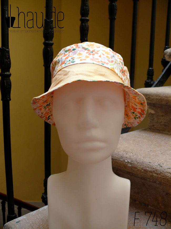 Bob court en sergé jaune pâle et tissu blanc imprimé de fleurs oranges et roses Bord jaune, bande centrale fleurs, sommet jaune, vu de face sur une tête de mannequin Sur l'envers les bandes sont inversées