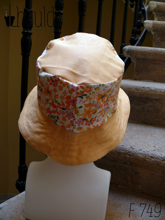 Bob classique en sergé jaune pâle et tissu blanc imprimé de fleurs oranges et roses Bord jaune, bande centrale fleurs, sommet jaune, vu de dos sur une tête de mannequin Sur l'envers les bandes sont inversées