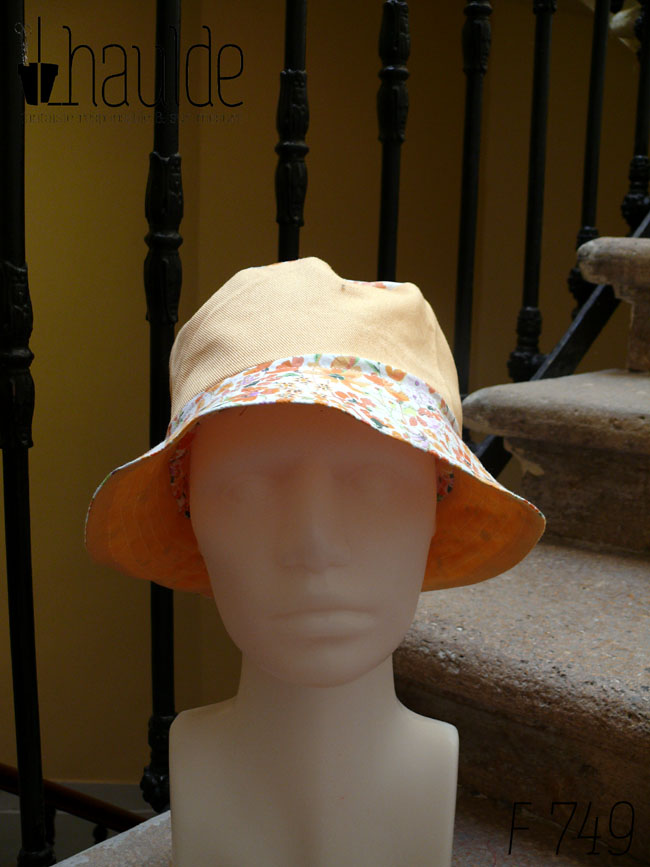 Bob classique en sergé jaune pâle et tissu blanc imprimé de fleurs oranges et roses Bord fleurs, bande centrale jaune, sommet fleurs, vu de face sur une tête de mannequin Sur l'envers les bandes sont inversées