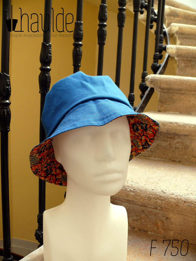 Bob en tissu imprimé orange, motifs végétaux stylisés bleus roi et blancs L'envers est en sergé bleu roi Vu de face côté envers uni sur une tête de mannequin