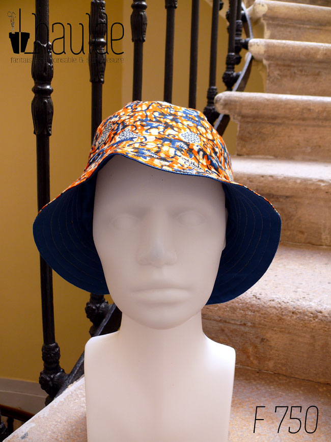 Bob en tissu imprimé orange, motifs végétaux stylisés bleus roi et blancs L'envers est en sergé bleu roi Vu de face sur une tête de mannequin