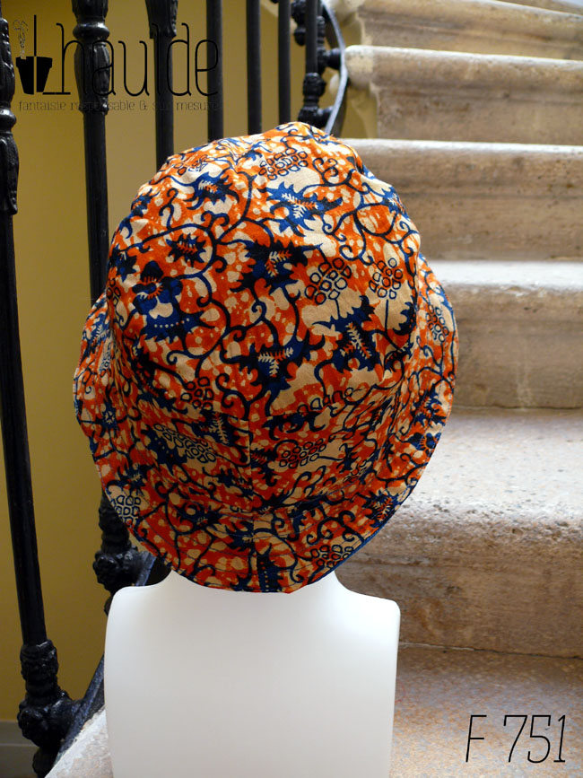 Bob court en tissu imprimé orange, motifs végétaux stylisés bleus roi et blancs L'envers est en sergé bleu roi Vu de dos sur une tête de mannequin
